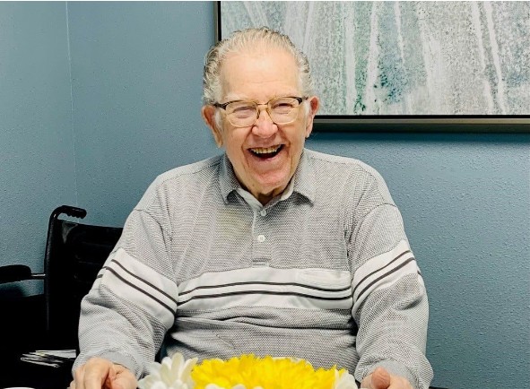 Smiling senior gentleman enjoying a meal at his community